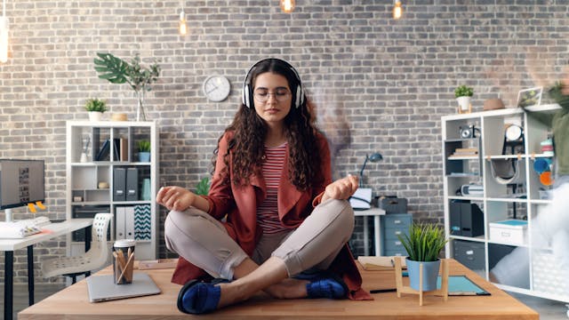 Professional performing 8 minutes desk yoga stretch routine at their workspace 