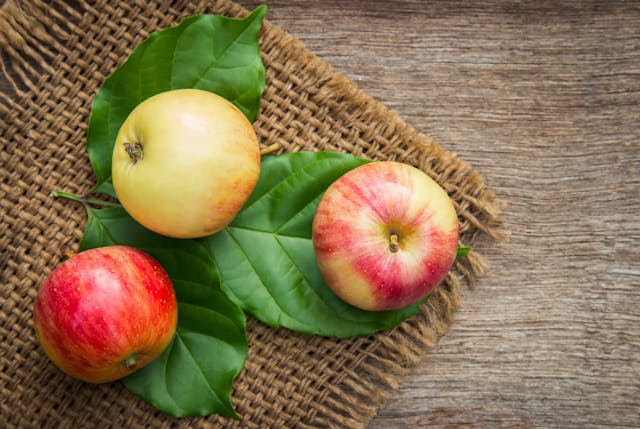 Fresh apples on a wooden table representing the Health Benefits of Apples