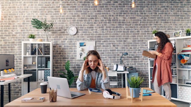 Person practicing mindful stretch in office for mental health benefits of desk yoga stretch routine 