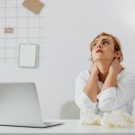 Person performing seated neck rolls as part of a desk yoga stretch routine 