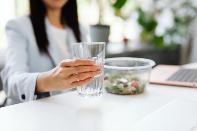 Healthy snacks and water next to workstation with focus on desk yoga stretch routine 