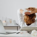 Employee practicing seated forward fold with desk hold in yoga stretch routine 