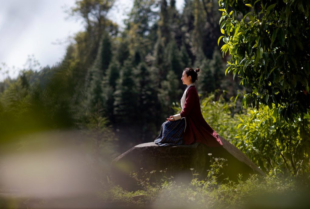 A peaceful nature setting with a person meditating at a budget wellness retreats