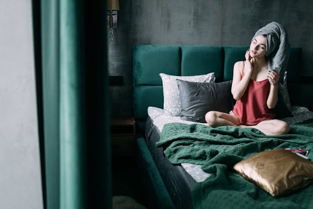 Woman applying green tea serum for glowing skin as part of her nighttime skincare routine