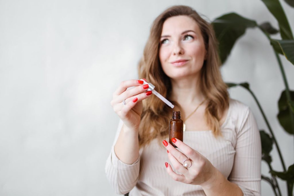 DIY green tea serum for glowing skin with natural ingredients like aloe vera, vitamin C, and essential oils displayed on a table