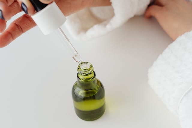 Green tea serum for glowing skin displayed with fresh leaves and skincare essentials