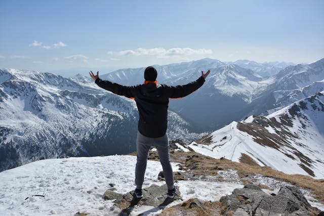 Traveler soaking in breathtaking view during unforgettable mountain adventures