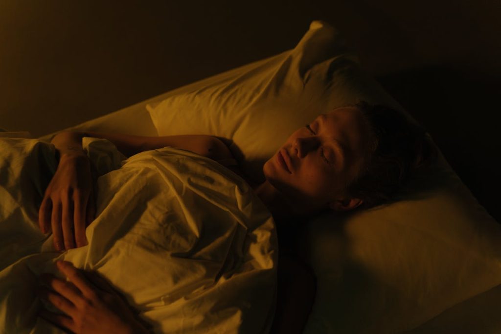 A peaceful woman practicing sleep meditation techniques for deep rest at night