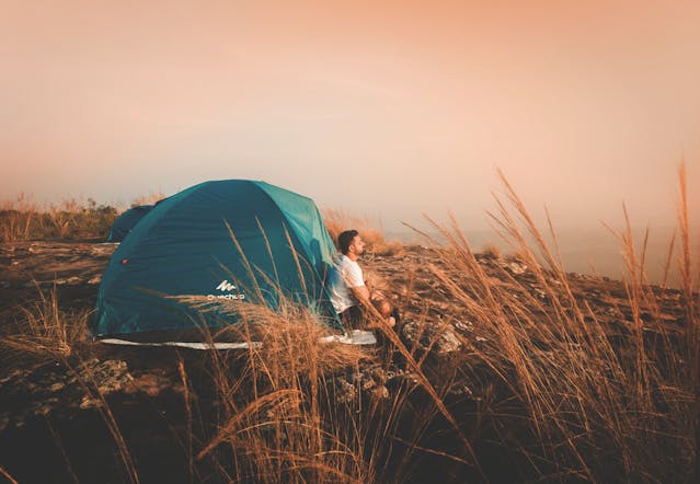A solo traveler reflecting peacefully during sunset – solo travel ideas