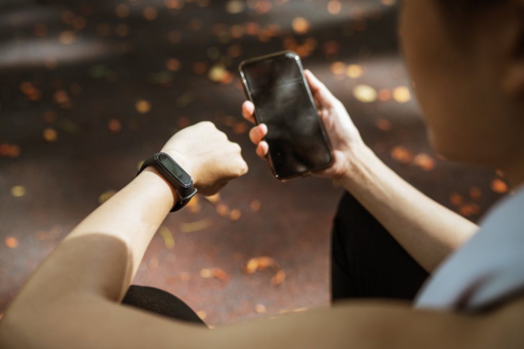 A person using wearable fitness trackers to monitor health, sleep, and workouts
